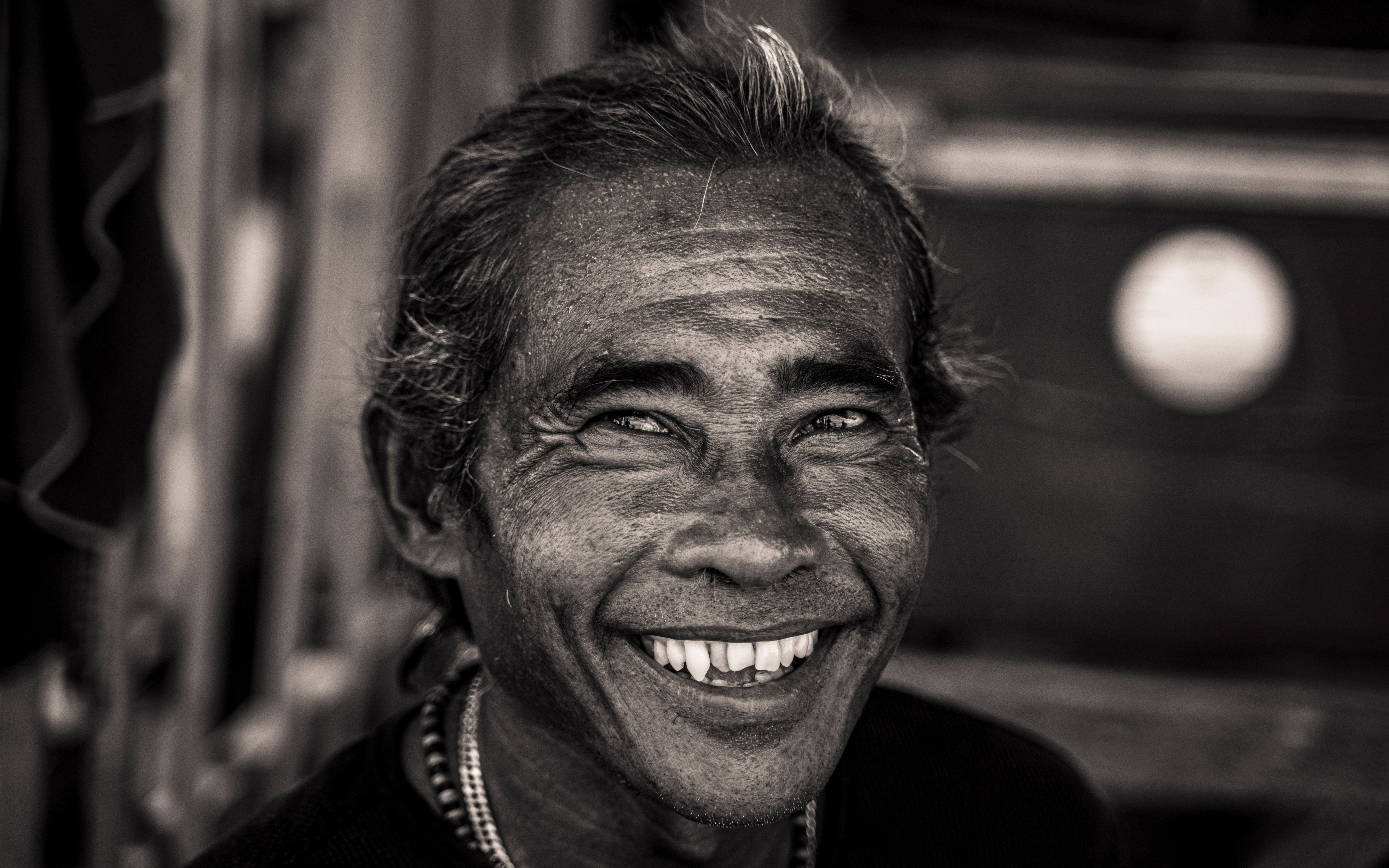 A warm smiling portrait of an elderly man in Bali, capturing cultural essence and wisdom.