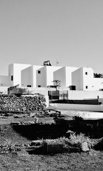 Monochrome image of modern white cubist buildings with clear sky backdrop, showcasing architectural contrast.