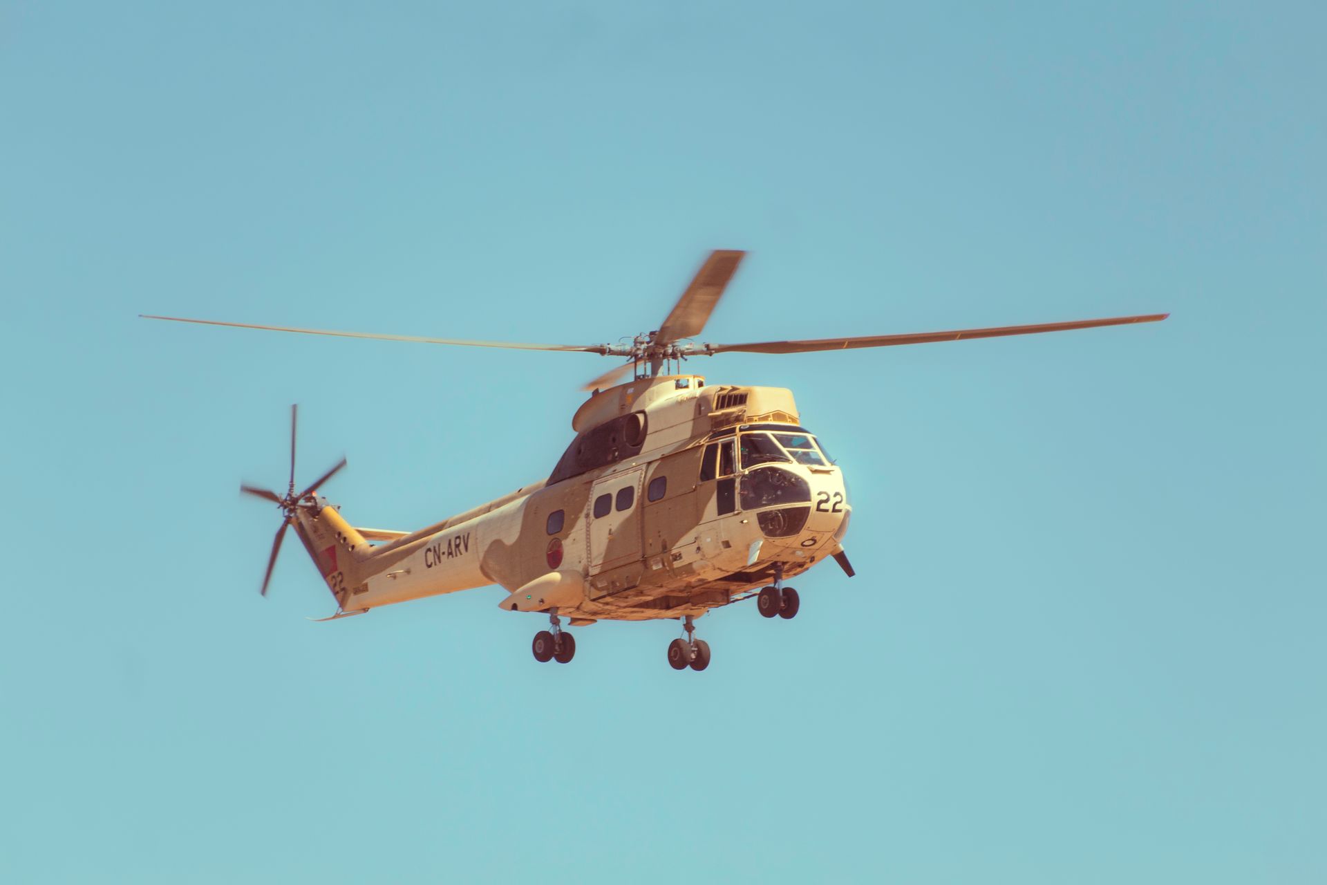 Puma helicopter of the Moroccan Air Force flying in clear blue skies.