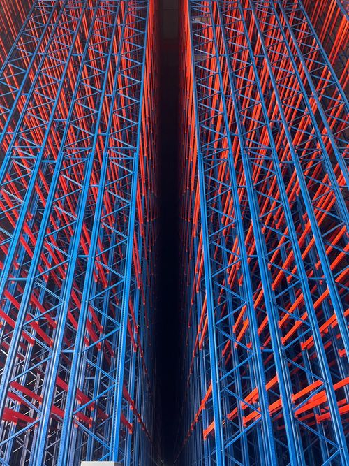 Free Colorful industrial storage racks creating a geometric pattern in a warehouse. Stock Photo