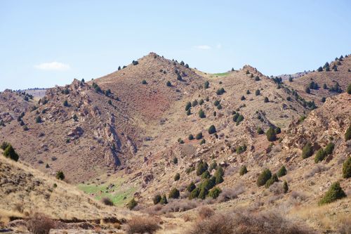 Free Idyllic view of rocky hills with sparse vegetation under clear blue sky. Stock Photo