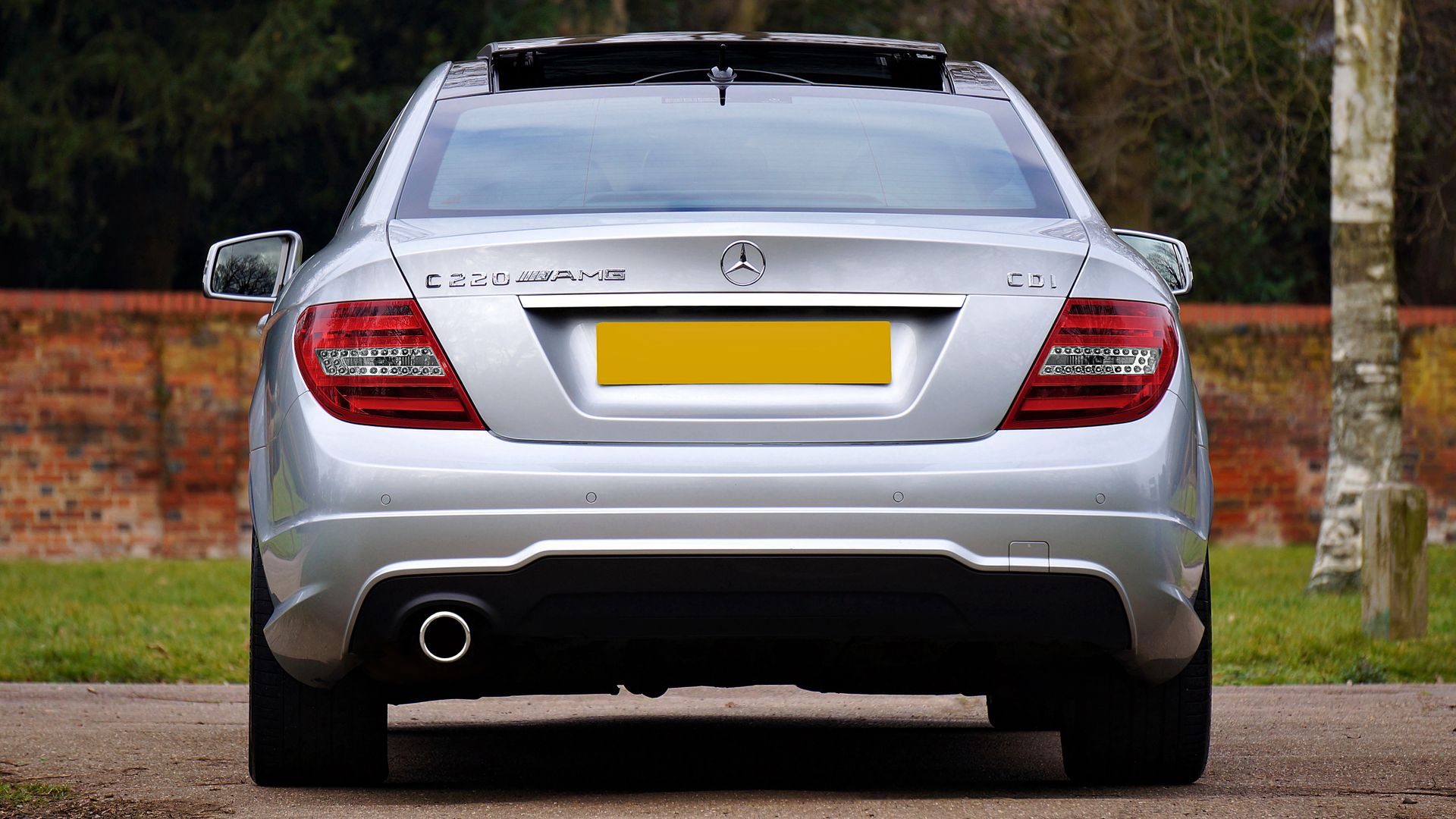 Rear view of a silver Mercedes-Benz C220 coupe parked outdoors — msrp meaning