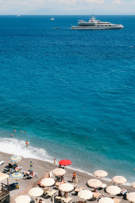 Relaxing summer beach scene on the Amalfi Coast with a luxury yacht.