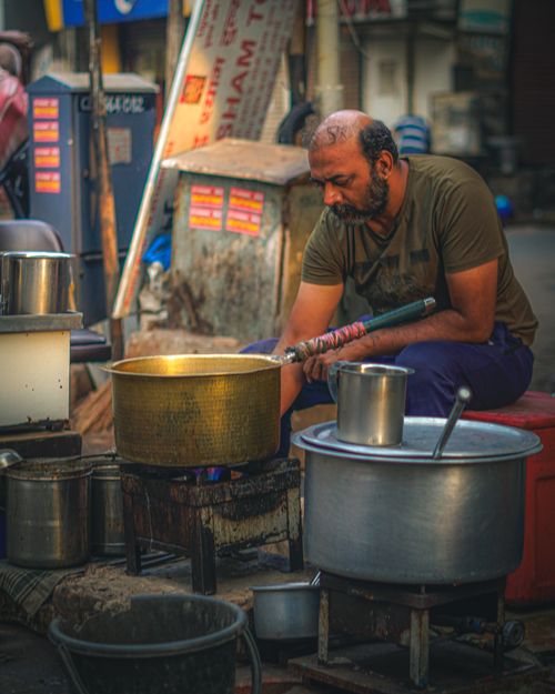 Free A street vendor skillfully cooks outdoors in Ahmedabad, capturing the lively market atmosphere. Stock Photo