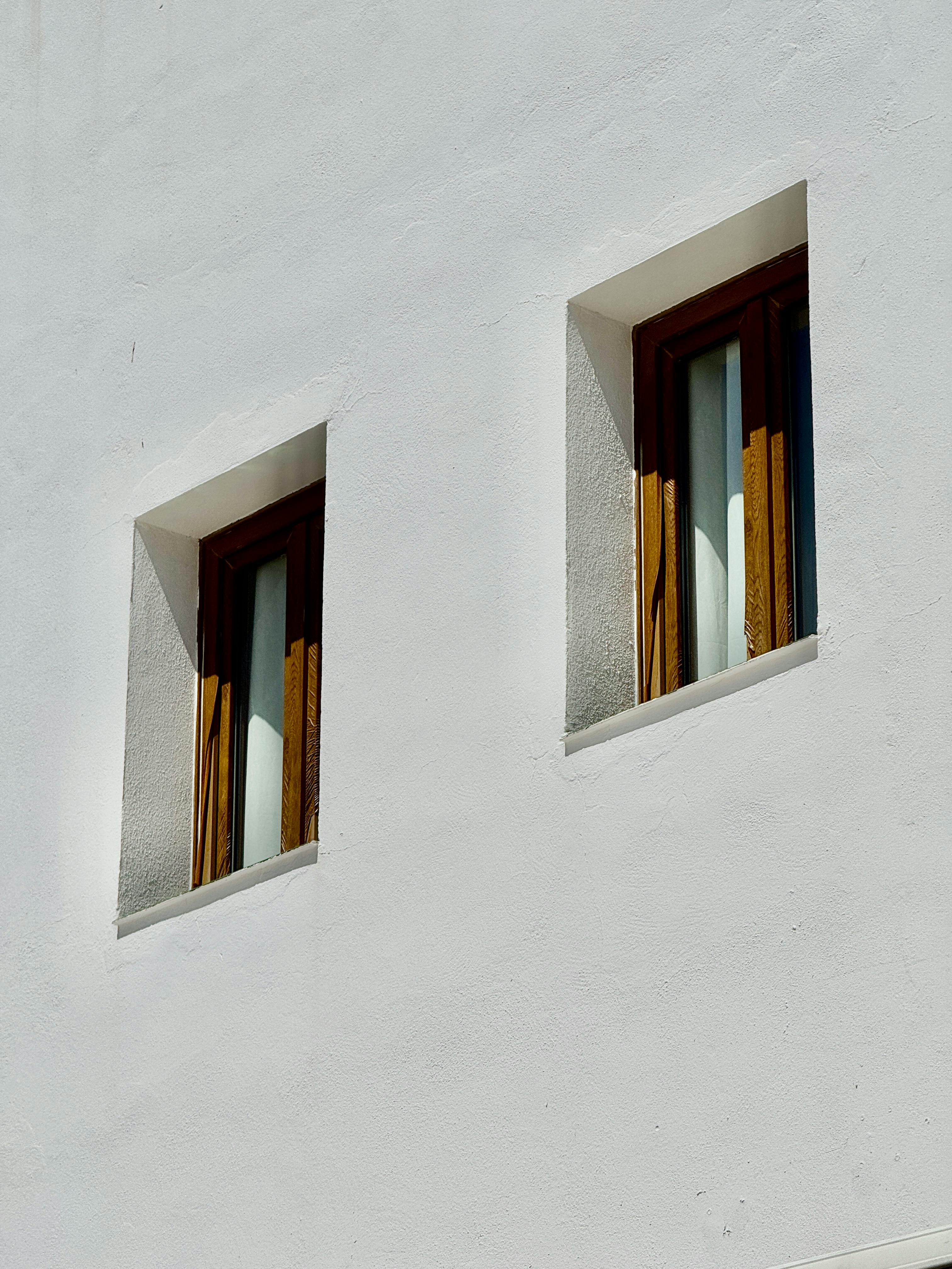 Two minimalist window frames on a white stucco wall in Cádiz, Spain.