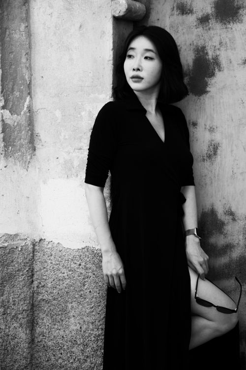 Free Stylish black and white portrait of a woman standing against a textured wall. Stock Photo
