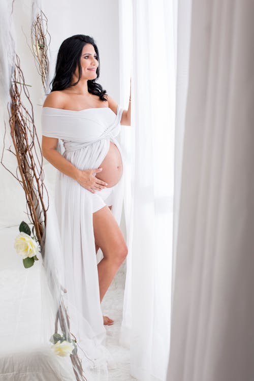 Free Беременная женщина, глядя в окно Stock Photo