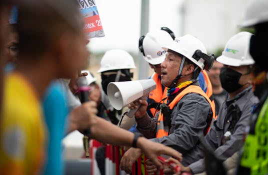Construction workers in a heated protest with security present. Safety and communication emphasized.