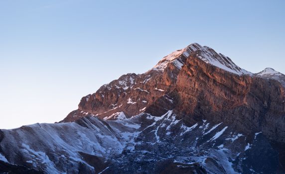 Captivating view of snow-covered mountain peaks at sunset in the Pyrenees, Aragon, Spain.