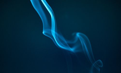 Free A captivating abstract image of twisting blue smoke against a dark background. Stock Photo