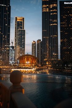 Evening view of Dubai Downtown skyline with illuminated skyscrapers and iconic architecture.