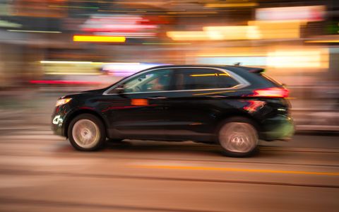A black SUV in motion on a city street