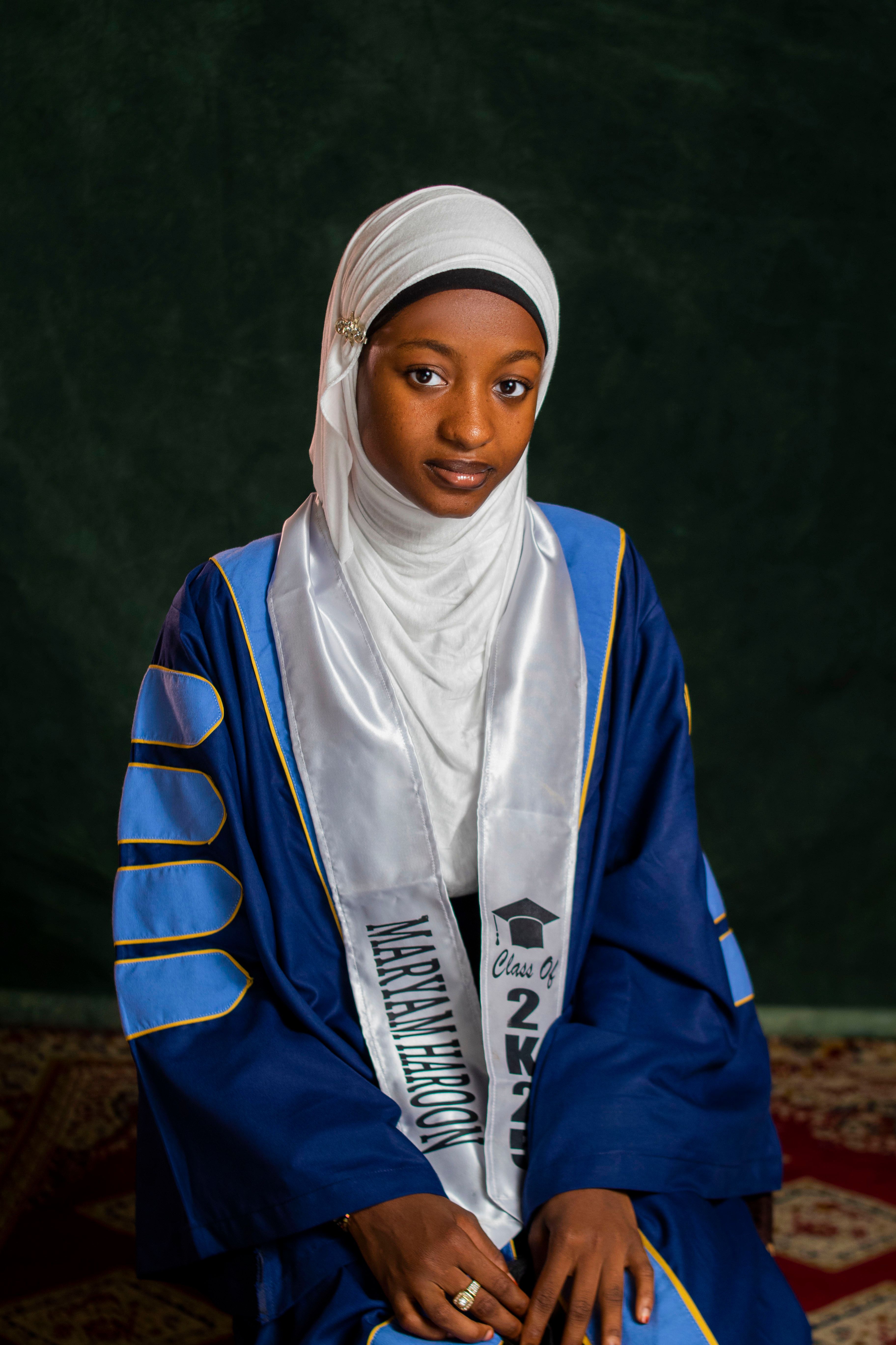 Portrait of a young graduate in academic gown and hijab, celebrating graduation.