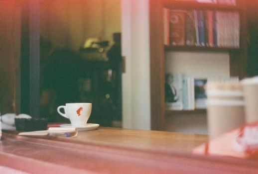 Warm, artistic view of a coffee cup on a wooden counter in an İstanbul café.