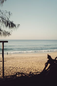 A serene view of Florianópolis beach with gentle waves and soft light at dawn. Perfect for relaxation themes.