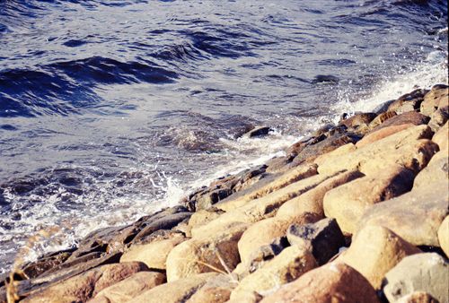 Free Calm waves gently hitting the rocky shore of the Baltic Sea in Gdańsk, Poland. Stock Photo