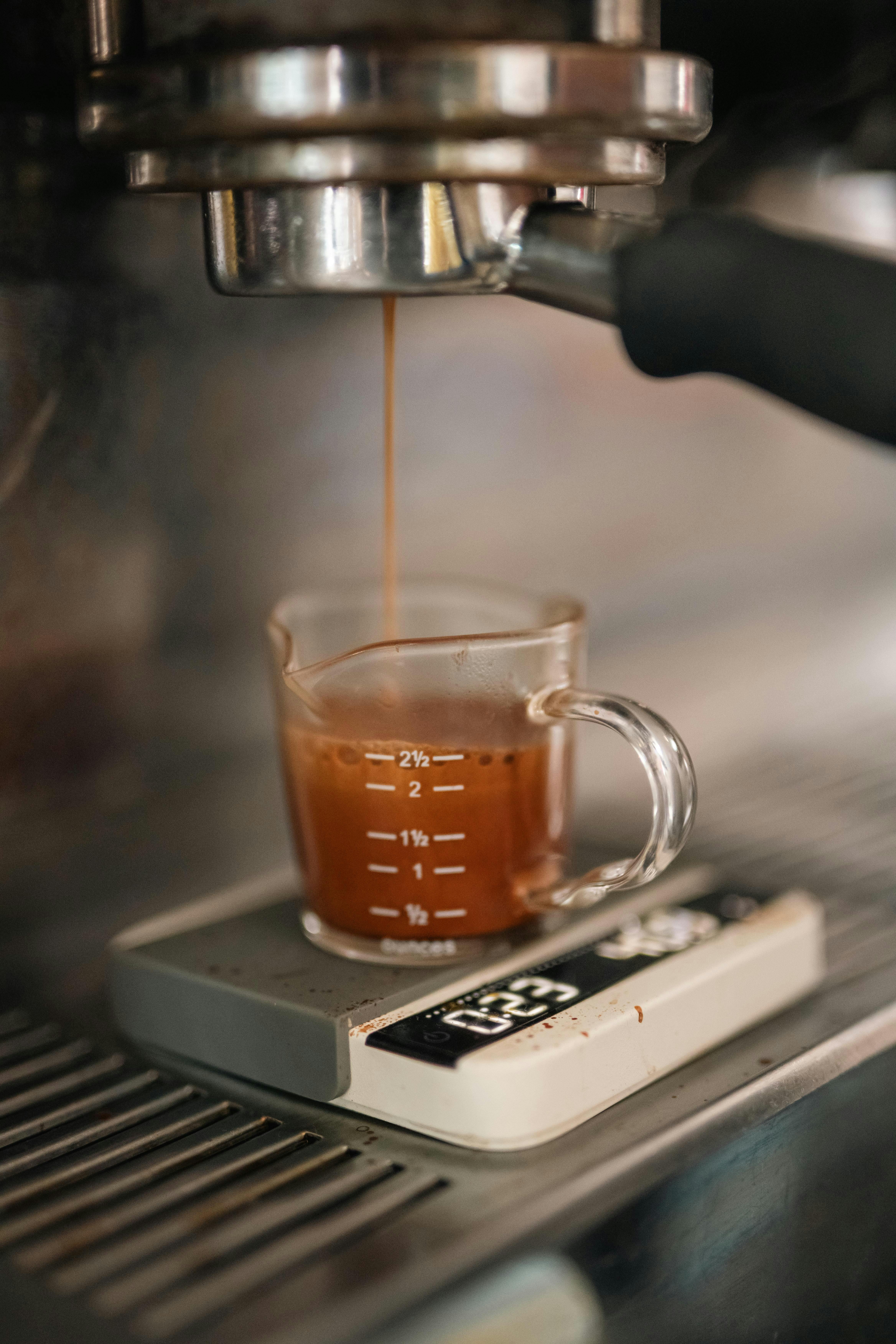Espresso dripping into glass cup on a compact scale