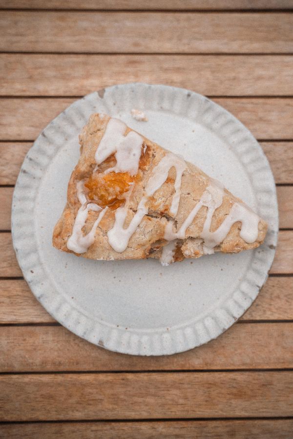 Glazed cinnamon scone on a ceramic plate — photo by James Collington on Pexels