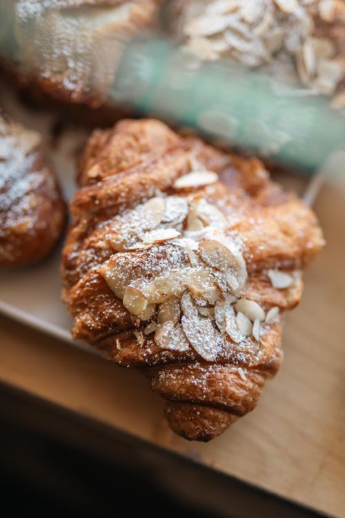 Free Delicious almond croissant with powdered sugar, perfect for breakfast treats. Stock Photo
