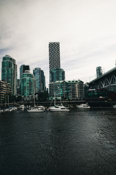 Stunning view of Vancouver's distinct skyline by the waterfront with boats.