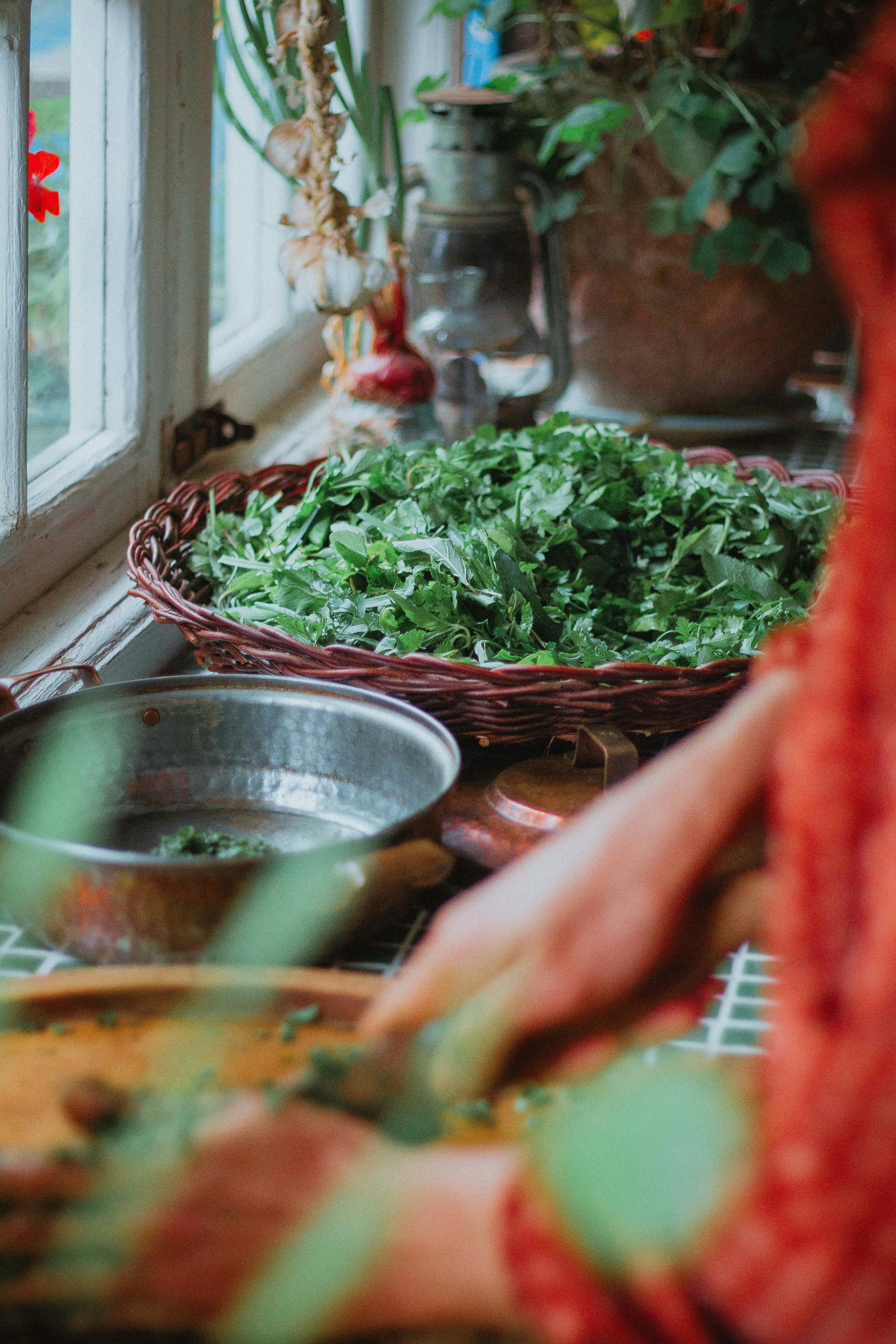 A cozy kitchen scene with herbs being chopped by the window light, exuding a rustic and natural vibe.