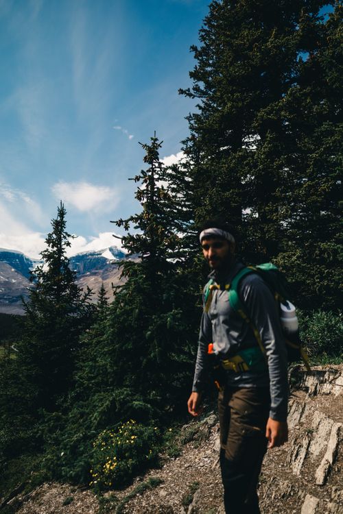 Free Explore the rugged beauty of Jasper, Alberta with a solo hiker in lush mountain wilderness. Stock Photo