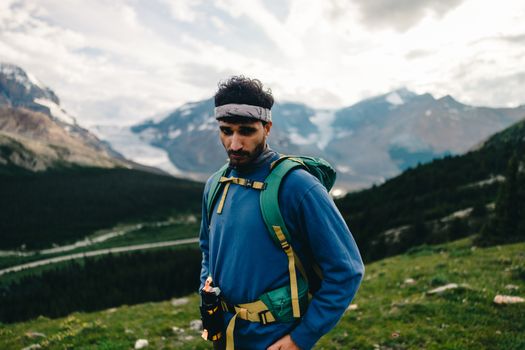 A hiker enjoys the breathtaking views of the mountains and wilderness in Jasper, Alberta.