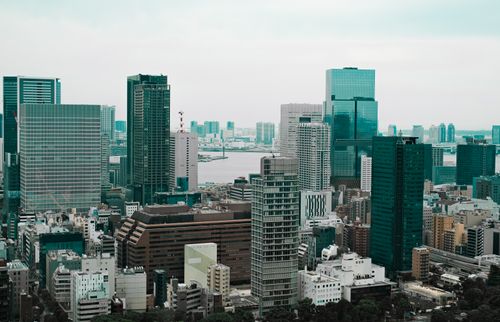 Free Aerial view of Tokyo's modern skyscrapers with a river backdrop, showcasing urban architecture. Stock Photo