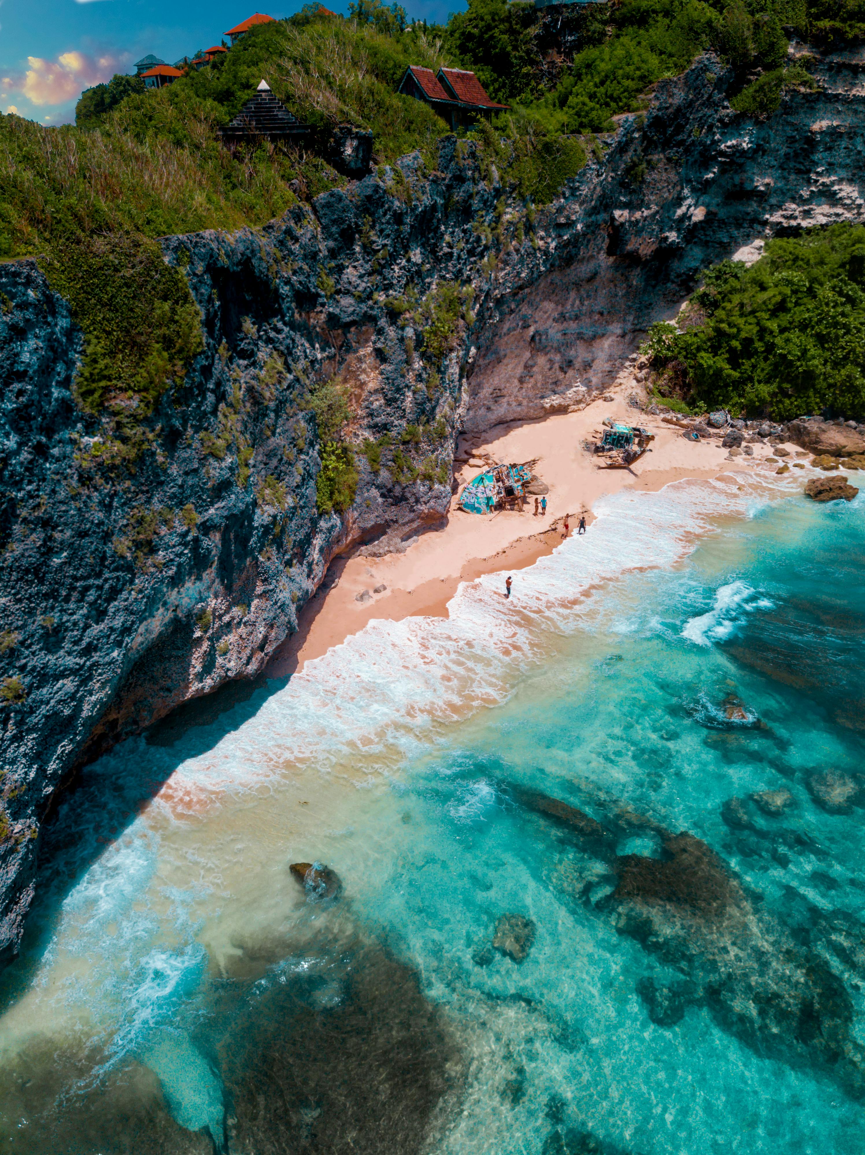 A breathtaking aerial view of the rocky cliffs and turquoise waters at Uluwatu Beach, Bali