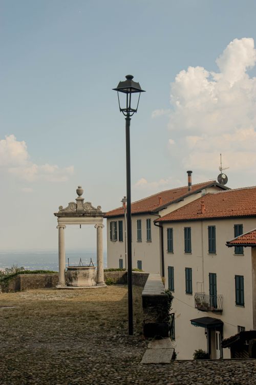 Free Scenic view of rustic Italian buildings and archway under a bright sky. Stock Photo
