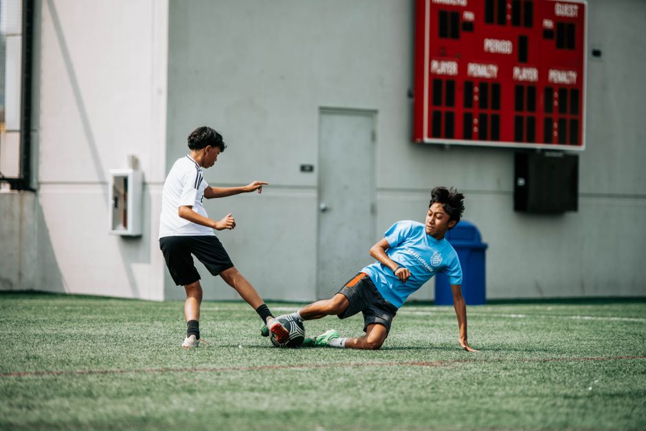 Soccer Shots 2 Young soccer players engage intensely on a sunny day in Milwaukee, showcasing action and sportsmanship. | BocaVibe