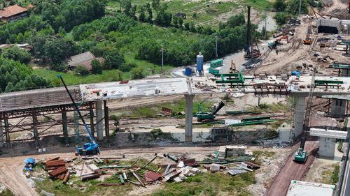 Free Aerial shot showing the construction of a bridge in a rural area of Vietnam, highlighting the progress and machinery involved. Stock Photo