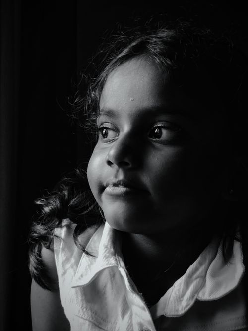 Free Black and white portrait of a young girl gazing out with thoughtful expression. Stock Photo