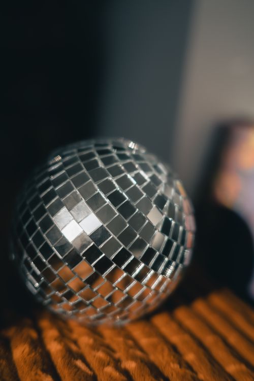 Free A shiny disco ball reflecting light in a dark room, capturing a retro party vibe. Stock Photo