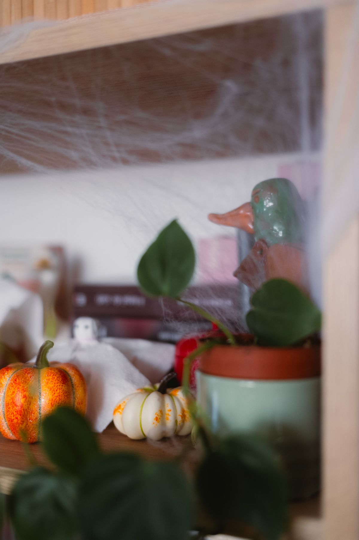 Decorative shelf with pumpkins, leaves, and Halloween ghost accents. Stock Photo.