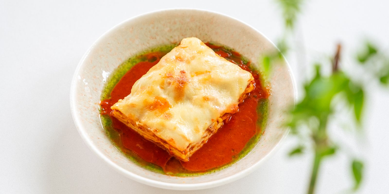 Homemade lasagna garnished with tomato and basil sauce