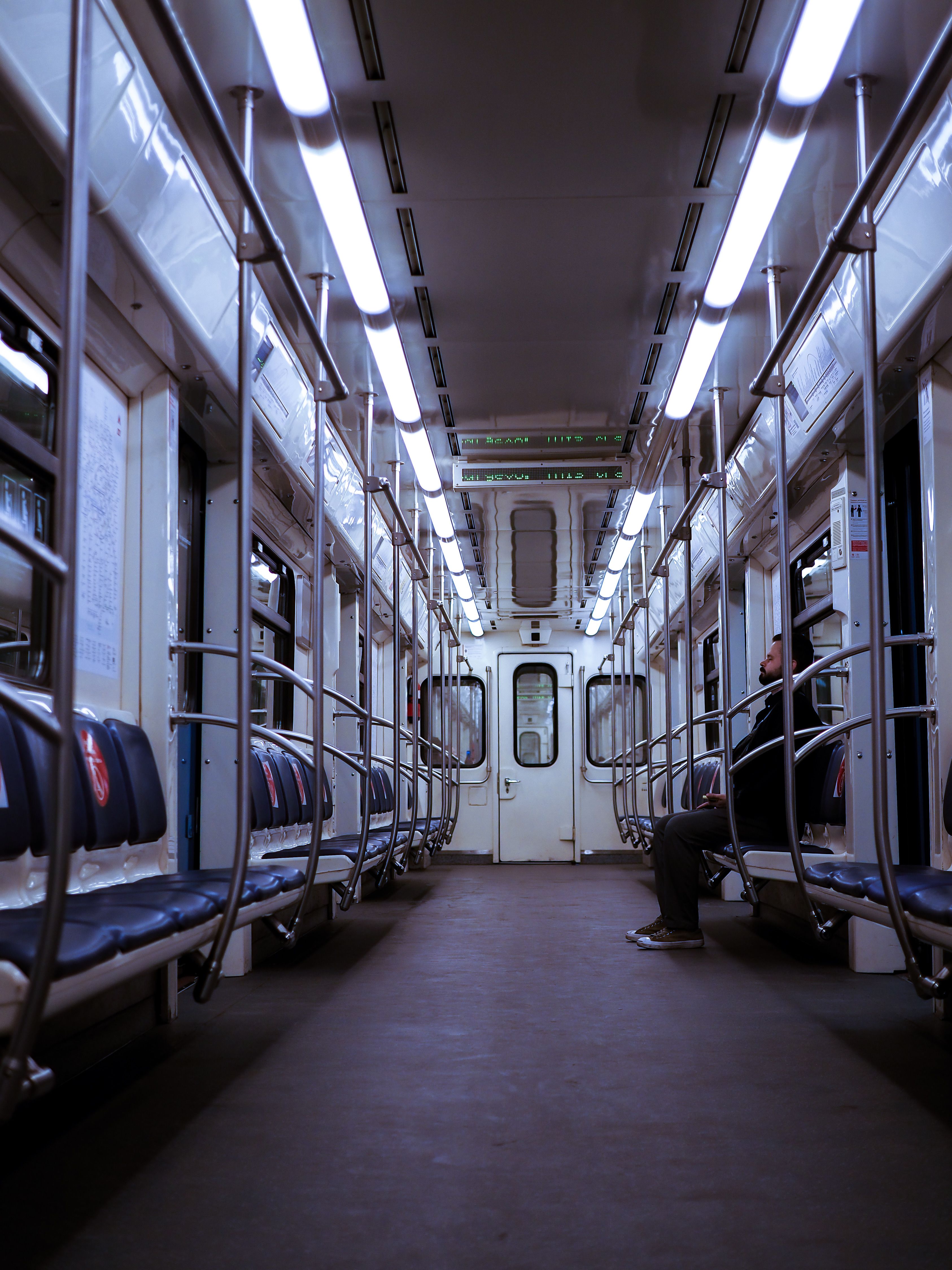 Free Quiet subway car interior with seating and overhead lights. Stock Photo