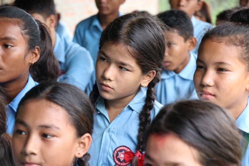 Free A diverse group of students in blue uniforms listening attentively in class. Stock Photo