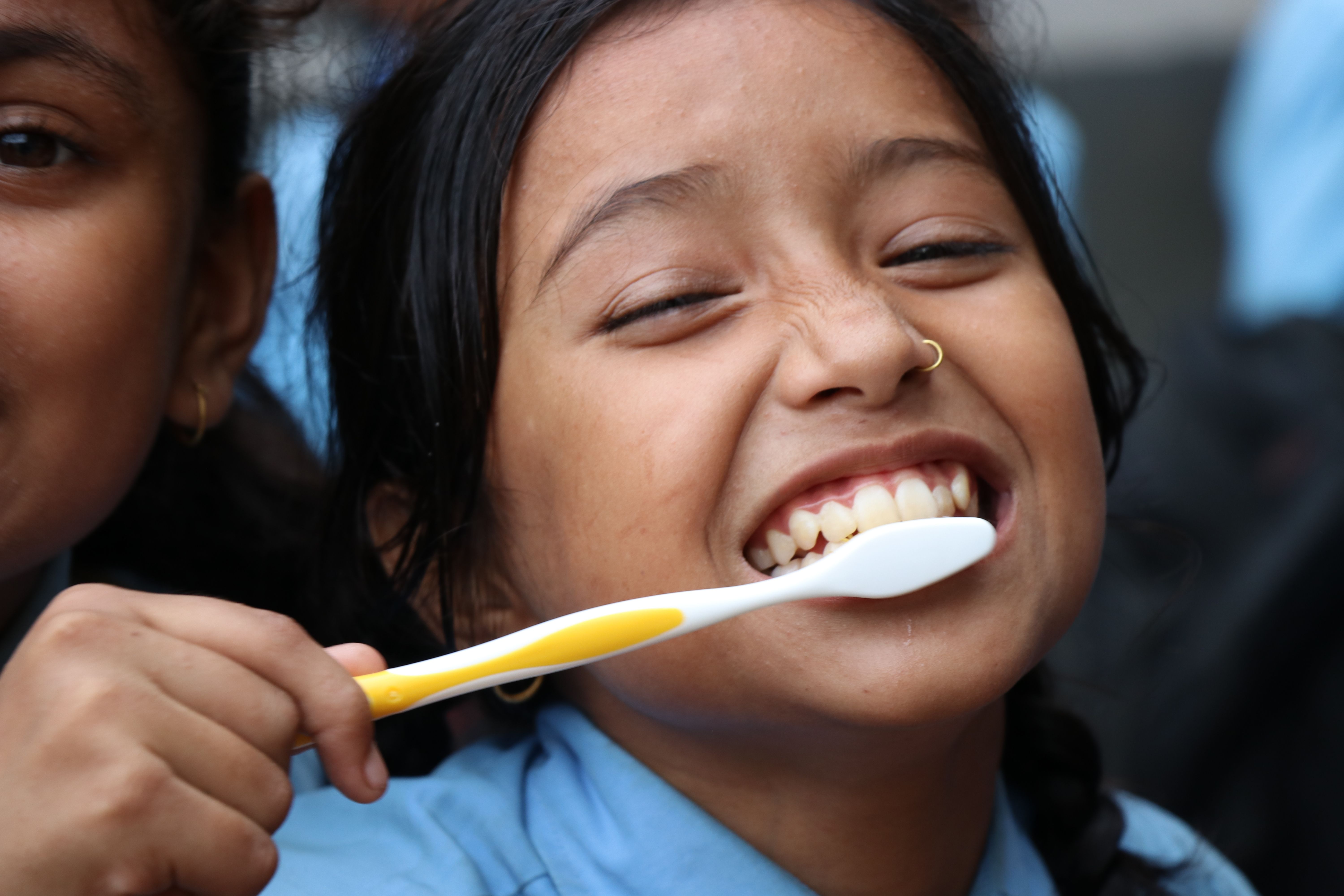 Criança sorrindo enquanto escova os dentes
