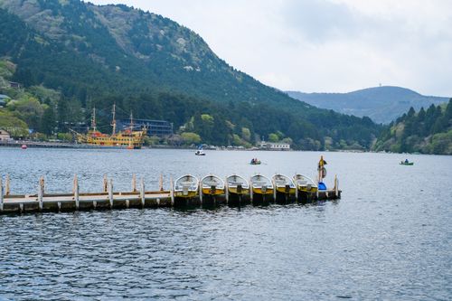 Free Beautiful view of Lake Ashi featuring a dock and a pirate-style ship in the distance. Stock Photo