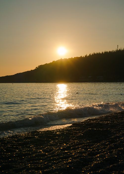 Free Serene beach sunset in Vlorë County, Albania, capturing golden hues and tranquil waves. Stock Photo