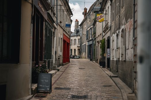 Explore a picturesque cobblestone street in Sancerre, France, showcasing historic architecture and cozy cafes.