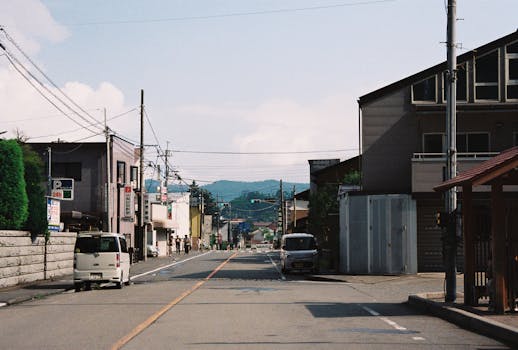 Quaint street in Yamanashi, Japan, featuring local architecture with mountains in the backdrop.