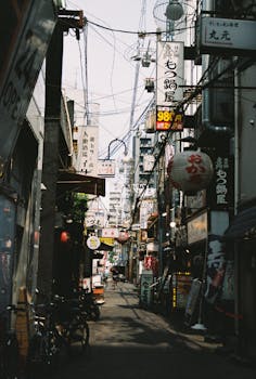 A bustling street in Osaka, Japan showcasing traditional architecture and vibrant daily life.