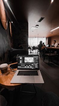 A modern coffee shop setting with a laptop and coffee, perfect for remote working.