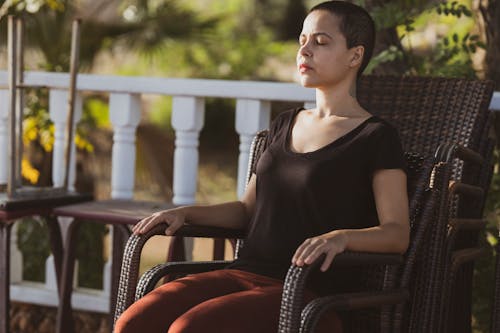 Woman in Black Top Sitting on Brown Armchair