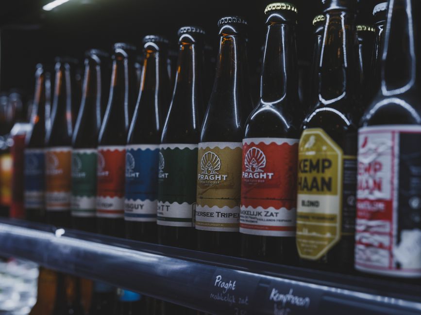 A selection of colorful craft beer bottles displayed on a shelf in a store in Almere, Netherlands.