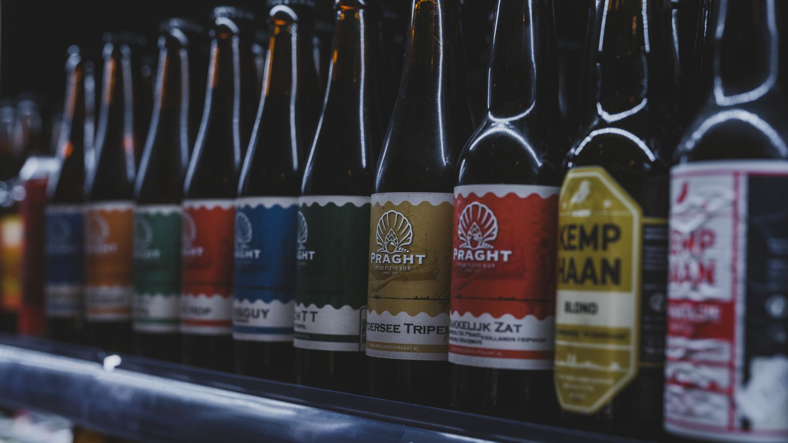 A selection of colorful craft beer bottles displayed on a shelf in a store in Almere, Netherlands.