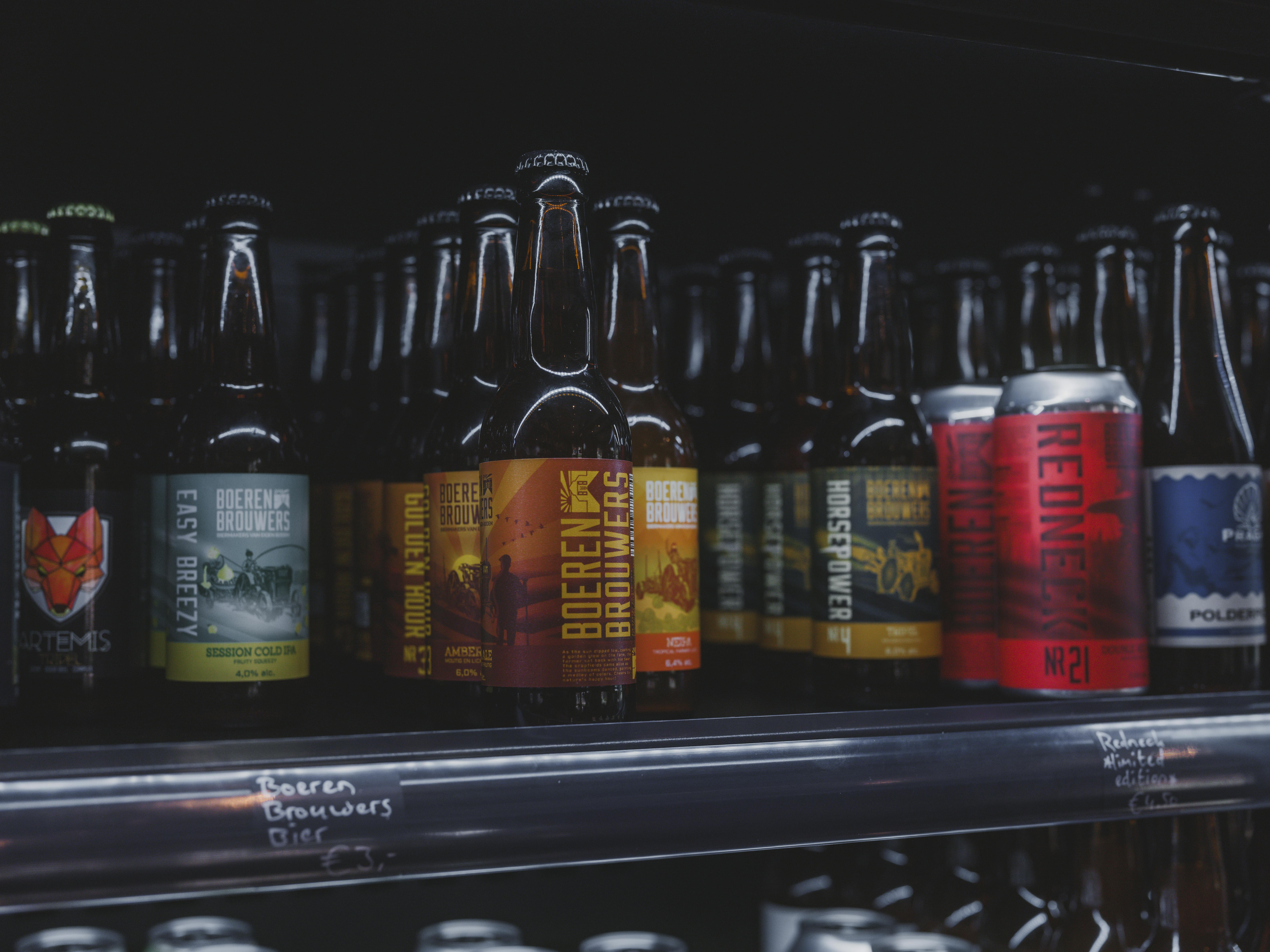 Assorted craft and local beers displayed on a store refrigerator shelf in Almere.