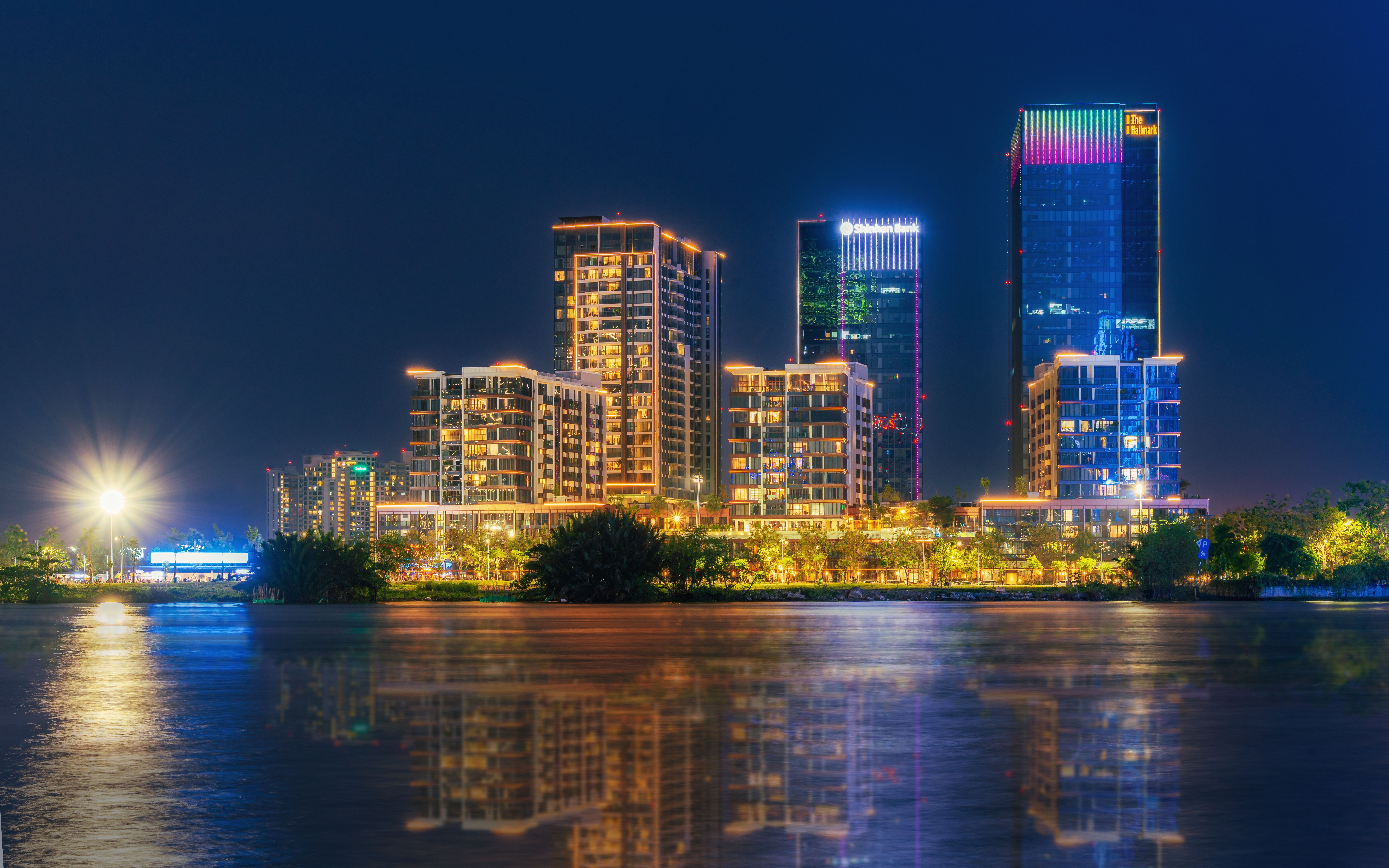 Illuminated Skyscrapers Reflecting on Water at Night · Free Stock Photo